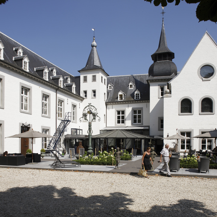 Chique modern wit kasteel in U-vorm met in het midden een terras.